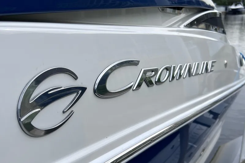 Slide: The Image of 2022 Crownline 290 XSS boat logo on sleek white and blue exterior. - 12
