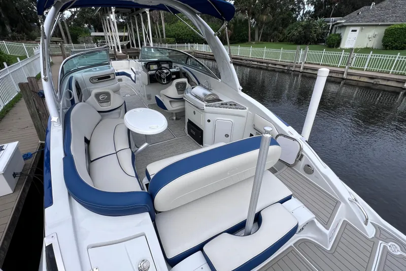 Slide: The Image of 2022 Crownline 290 XSS boat with luxurious seating and sleek design docked by a canal. - 15