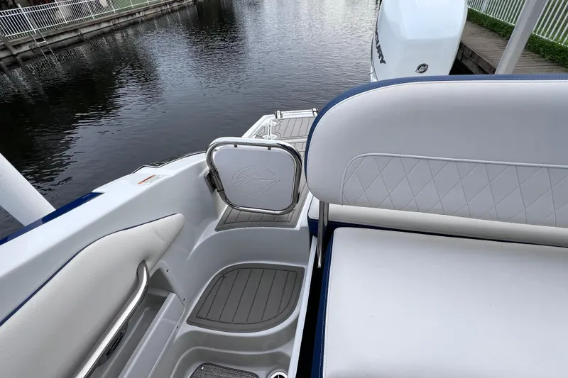 Slide: The Image of 2022 Crownline 290 XSS boat interior with white seating and water view. - 18
