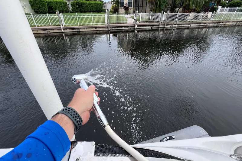 Slide: The Image of Man using boat shower on 2022 Crownline 290 XSS near waterfront. - 19