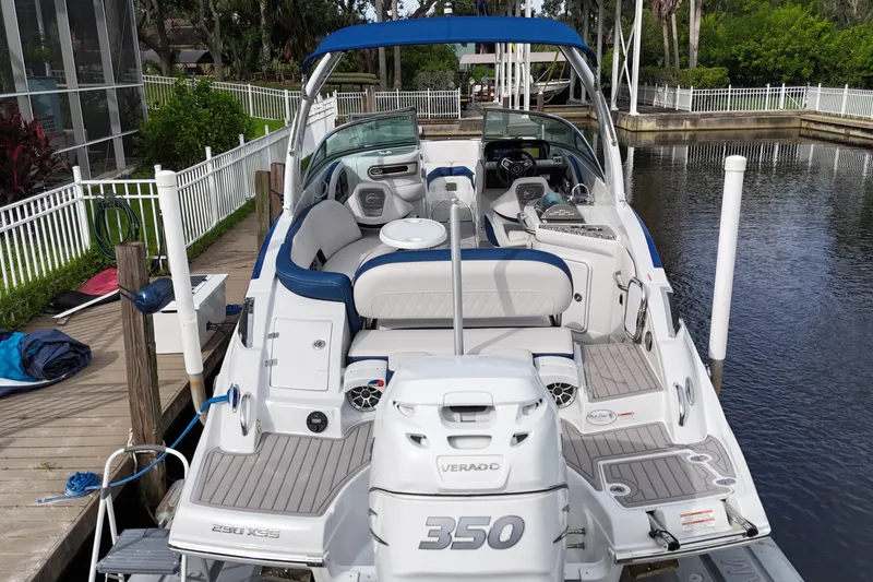 Slide: The Image of 2022 Crownline 290 XSS boat docked, featuring spacious seating and a powerful Verado 350 engine. - 2