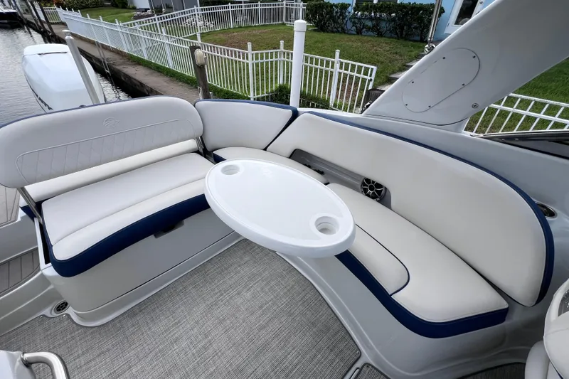 Slide: The Image of 2022 Crownline 290 XSS boat interior with white seating and round table. - 20