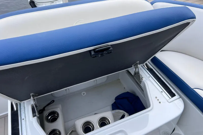 Slide: The Image of Open storage compartment on 2022 Crownline 290 XSS boat with cup holders. - 25