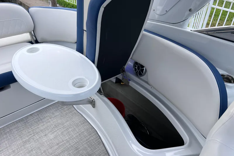 Slide: The Image of 2022 Crownline 290 XSS boat interior with seating, storage, and table. - 26