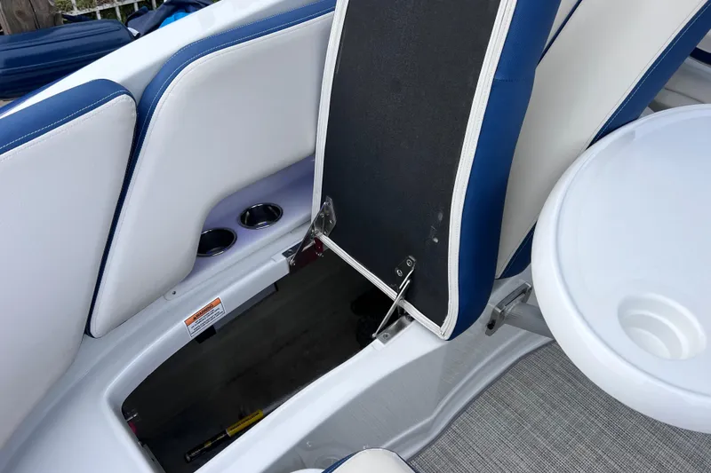 Slide: The Image of 2022 Crownline 290 XSS boat interior with open storage compartment and seating. - 27