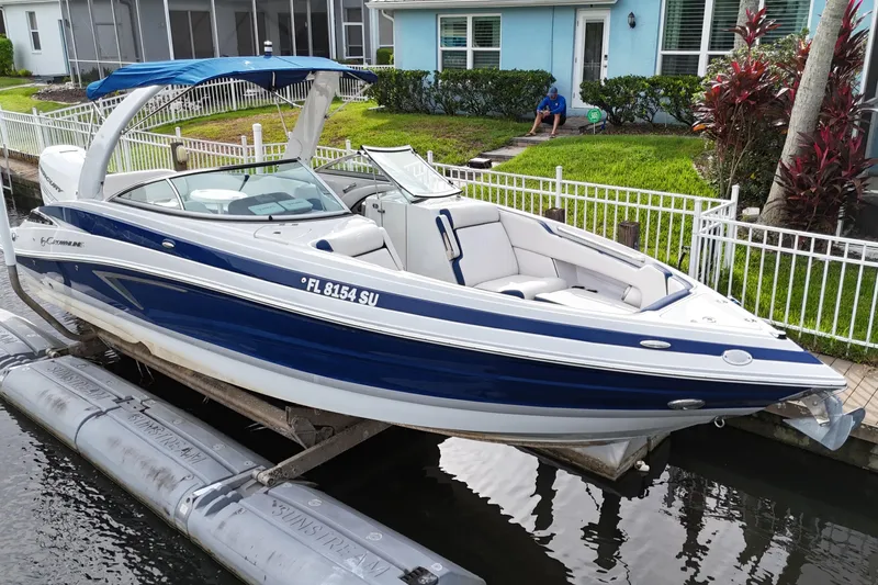 Slide: The Image of 2022 Crownline 290 XSS boat docked by a waterfront home. - 3