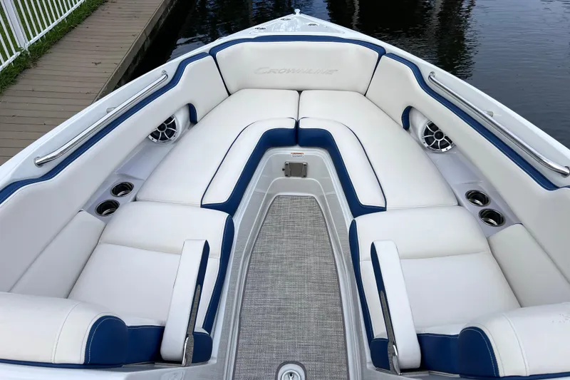 Slide: The Image of 2022 Crownline 290 XSS boat interior with white and blue seating, dockside view. - 42