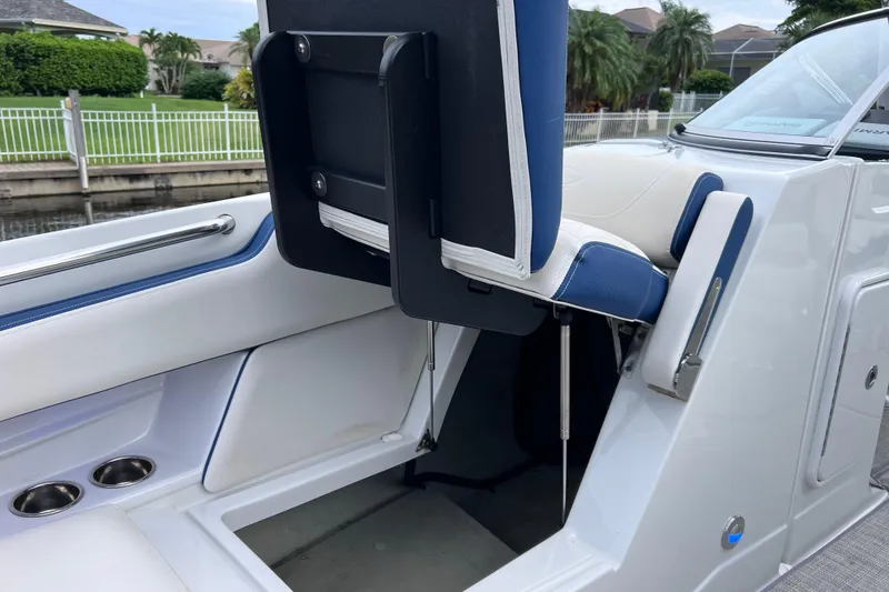 Slide: The Image of 2022 Crownline 290 XSS boat interior with blue and white seating, cup holders, and sleek design. - 46