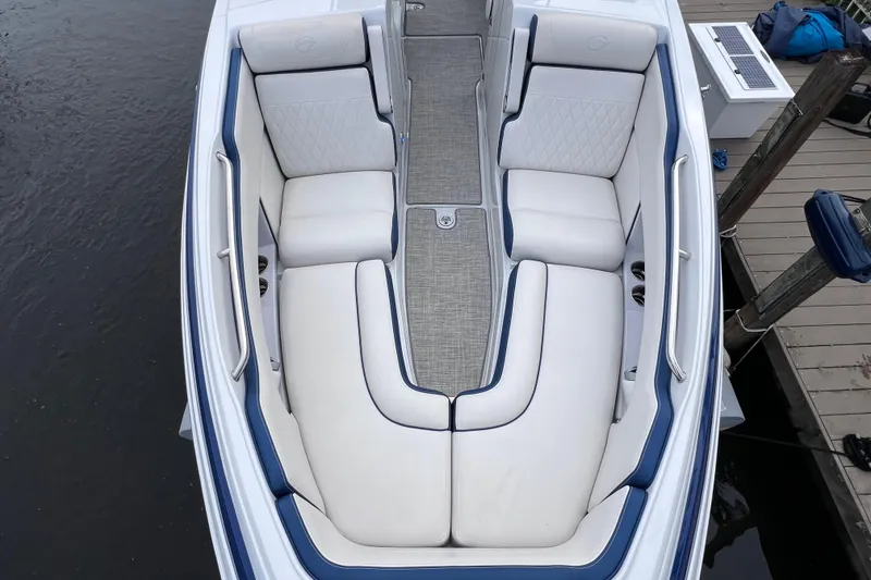 Slide: The Image of 2022 Crownline 290 XSS boat interior with white and blue seating, docked by water. - 50