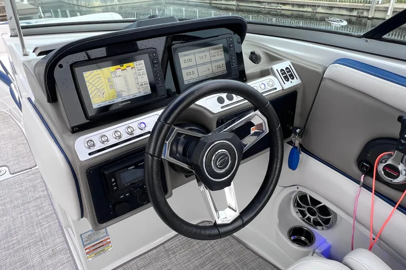 Slide: The Image of 2022 Crownline 290 XSS boat dashboard with steering wheel and navigation displays. - 51