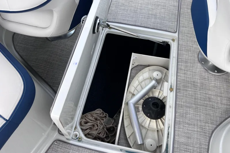Slide: The Image of 2022 Crownline 290 XSS boat storage compartment with rope and accessories. - 67