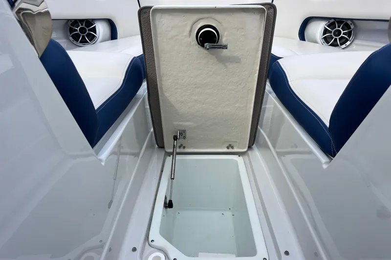 Slide: The Image of 2022 Crownline 290 XSS boat storage compartment with blue and white seating and speaker system. - 69