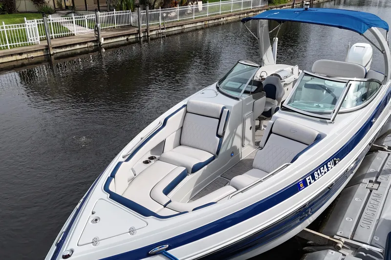 Slide: The Image of 2022 Crownline 290 XSS boat with blue accents docked on a calm canal. - 7