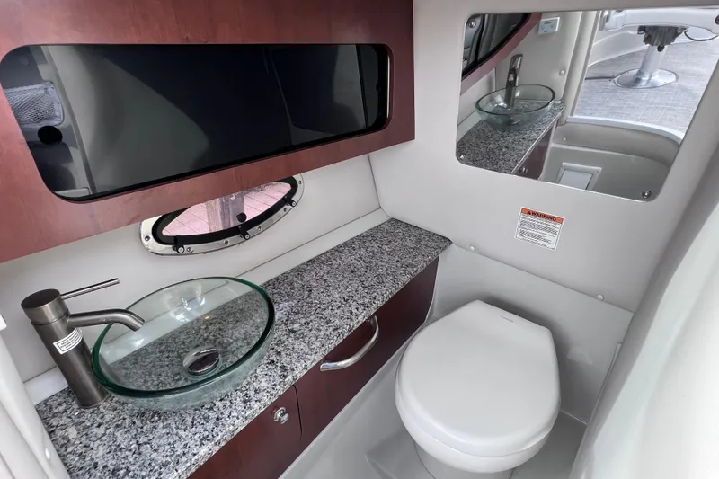 Slide: The Image of 2022 Crownline 290 XSS boat bathroom with modern sink, granite countertop, and mirror. - 72