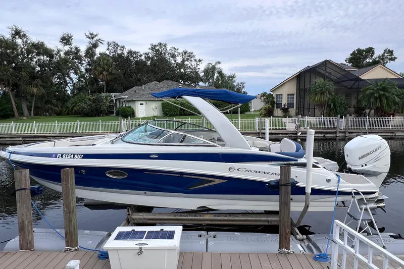 Slide: The Image of 2022 Crownline 290 XSS boat docked, featuring sleek design and blue accents. - 9