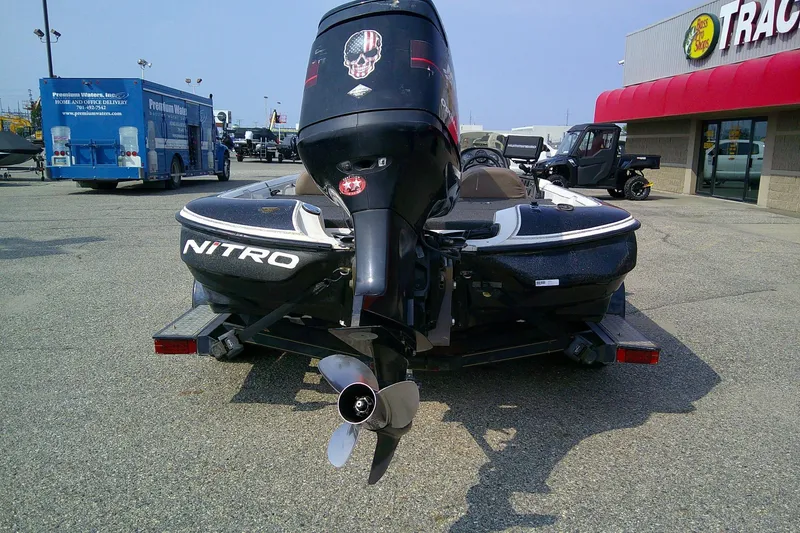 Slide: The Image of 1997 Nitro Savage 896 boat with outboard motor in parking lot near store. - 3
