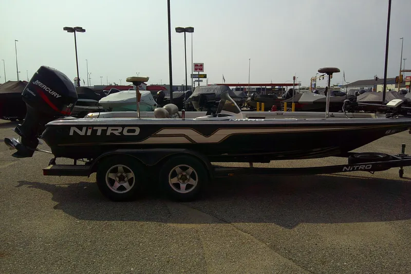 Slide: The Image of 1997 Nitro Savage 896 boat with Mercury outboard motor, parked on a trailer. - 6