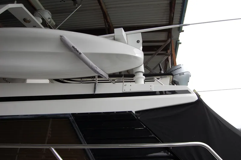 Slide: The Image of 1990 Ocean Alexander 520 Pilothouse yacht with Honda outboard motor, docked under shelter. - 10