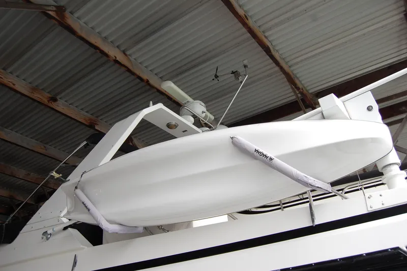 Slide: The Image of 1990 Ocean Alexander 520 Pilothouse yacht with covered lifeboat under a metal roof. - 11