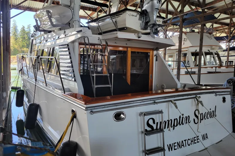 Slide: The Image of 1990 Ocean Alexander 520 Pilothouse docked in a marina, featuring sleek design and wooden accents. - 2