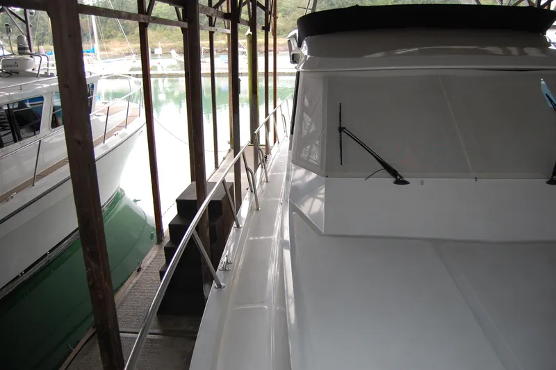 Slide: The Image of 1990 Ocean Alexander 520 Pilothouse yacht docked in a covered marina. - 20