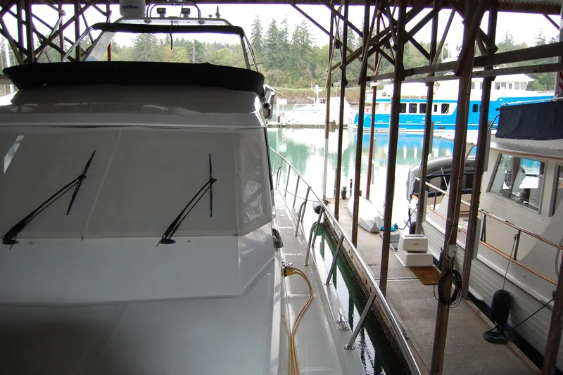 Slide: The Image of 1990 Ocean Alexander 520 Pilothouse yacht docked in a marina, surrounded by other boats. - 21