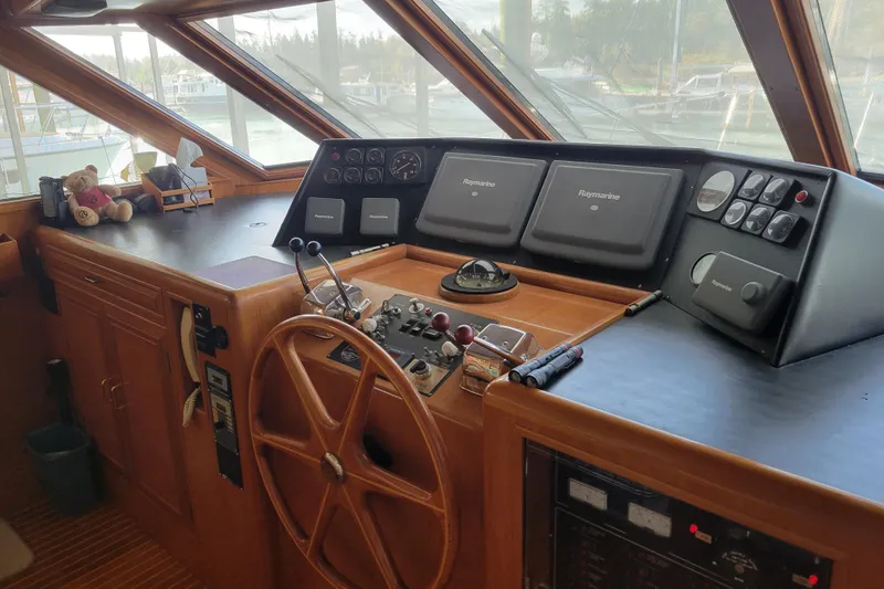 Slide: The Image of Pilothouse interior of 1990 Ocean Alexander 520, featuring navigation equipment and wooden steering wheel. - 22