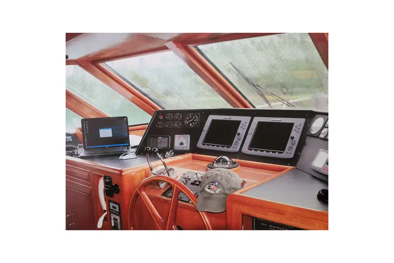 Slide: The Image of Pilothouse interior of 1990 Ocean Alexander 520, featuring navigation equipment and wooden steering wheel. - 23