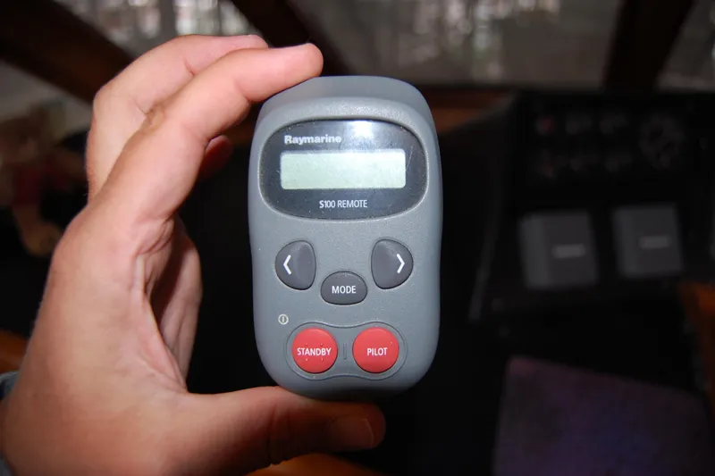 Slide: The Image of Hand holding Raymarine S100 remote control on Ocean Alexander 520 Pilothouse, 1990 model. - 25