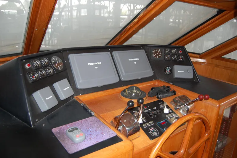 Slide: The Image of Pilothouse of 1990 Ocean Alexander 520, featuring Raymarine navigation equipment and wooden steering wheel. - 26