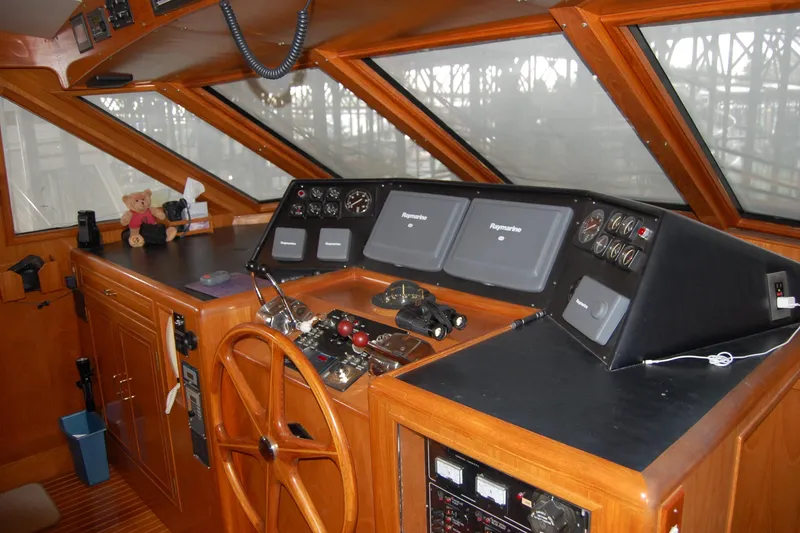 Slide: The Image of Pilothouse interior of 1990 Ocean Alexander 520, featuring navigation equipment and wooden steering wheel. - 29