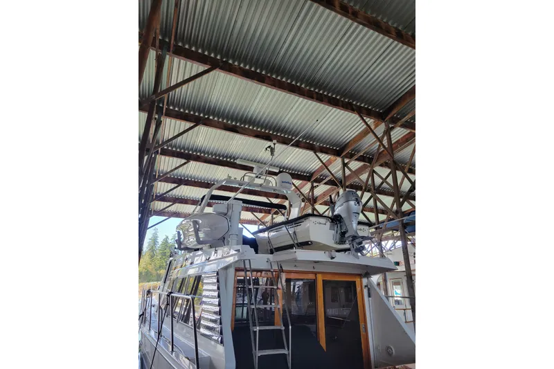 Slide: The Image of 1990 Ocean Alexander 520 Pilothouse yacht docked under a metal roof. - 3
