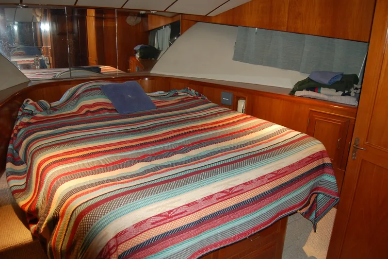Slide: The Image of Cozy bedroom in 1990 Ocean Alexander 520 Pilothouse with striped bedding and wooden cabinetry. - 35