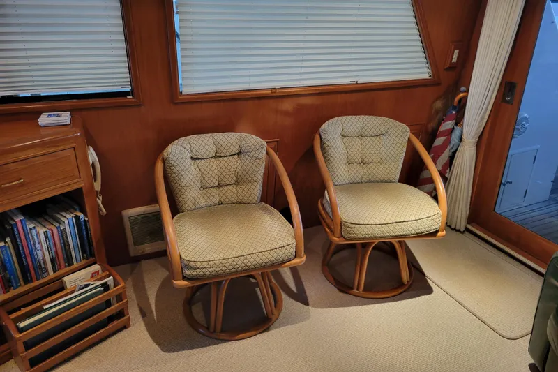 Slide: The Image of Interior of 1990 Ocean Alexander 520 Pilothouse with two cushioned chairs and bookshelf. - 61