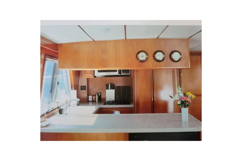Slide: The Image of Interior of 1990 Ocean Alexander 520 Pilothouse with wooden cabinetry and floral arrangement. - 64