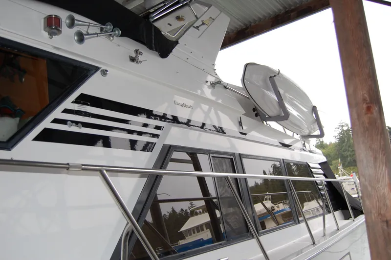 Slide: The Image of 1990 Ocean Alexander 520 Pilothouse yacht docked under a covered area. - 7