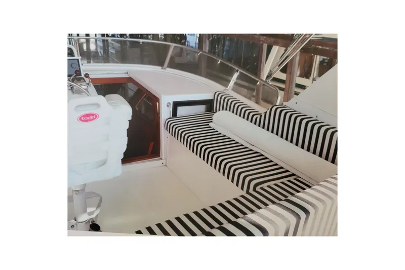 Slide: The Image of 1990 Ocean Alexander 520 Pilothouse interior with striped seating and helm station. - 76