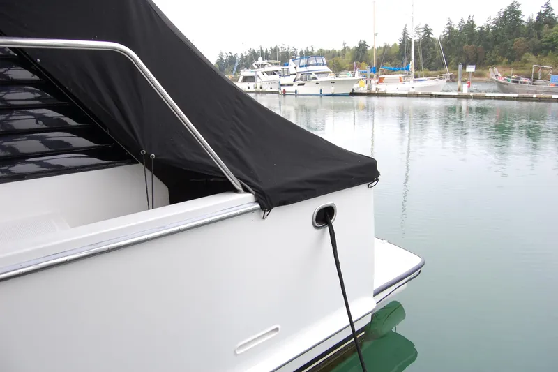 Slide: The Image of 1990 Ocean Alexander 520 Pilothouse docked at marina, covered with black tarp. - 9