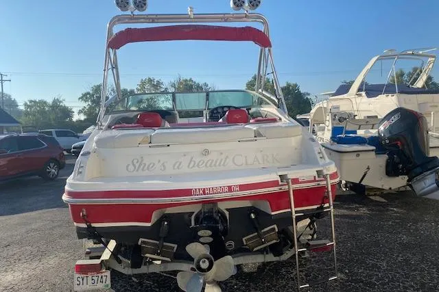 Slide: The Image of 2012 Rinker Captiva 216 BR boat with red accents, parked in a marina. - 10
