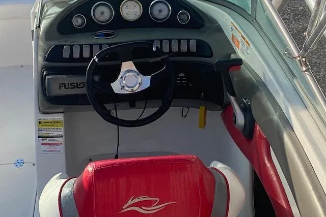 Slide: The Image of 2012 Rinker Captiva 216 BR boat dashboard with red and white seating. - 3