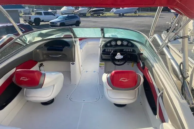 Slide: The Image of 2012 Rinker Captiva 216 BR boat interior with red and white seating, dashboard, and steering wheel. - 6