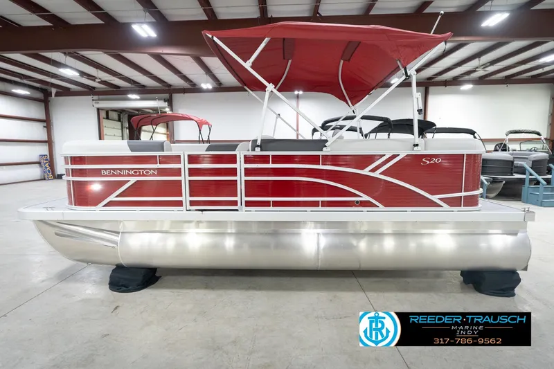 Slide: The Image of 2026 Bennington 20 SL pontoon boat with red exterior and canopy in showroom. - 11