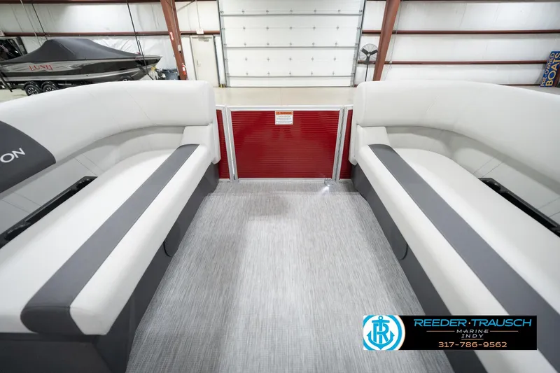 Slide: The Image of 2026 Bennington 20 SL pontoon boat interior with white seating in a showroom. - 21