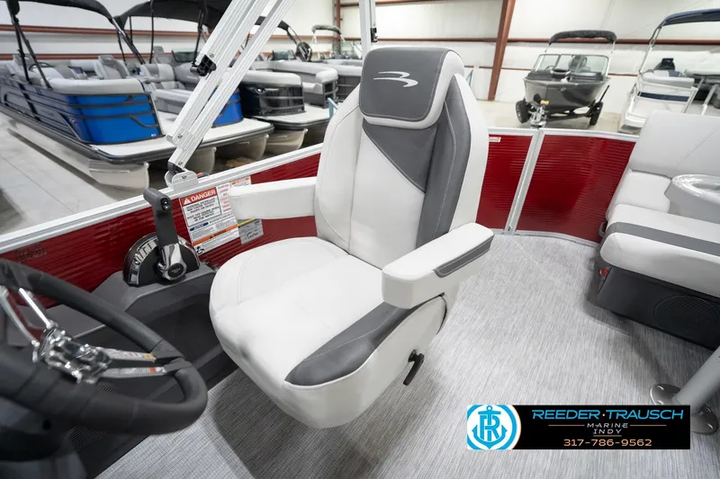 Slide: The Image of 2026 Bennington 20 SL boat interior with captain's chair and steering wheel in showroom. - 27