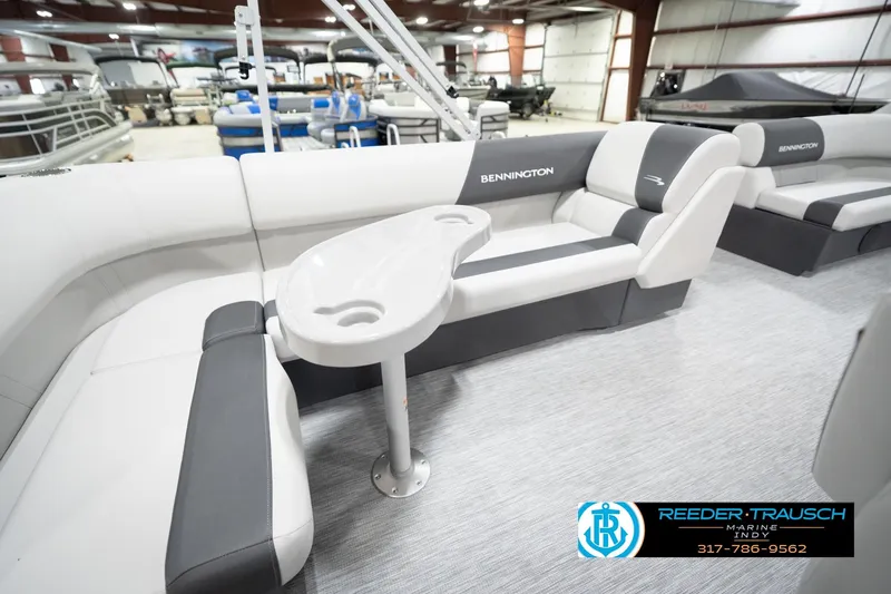 Slide: The Image of 2026 Bennington 20 SL pontoon boat interior with gray seating and table in showroom. - 28