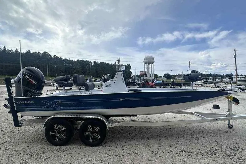 Slide: The Image of 2026 Xpress H22 boat on trailer, blue and white design, parked outdoors. - 12