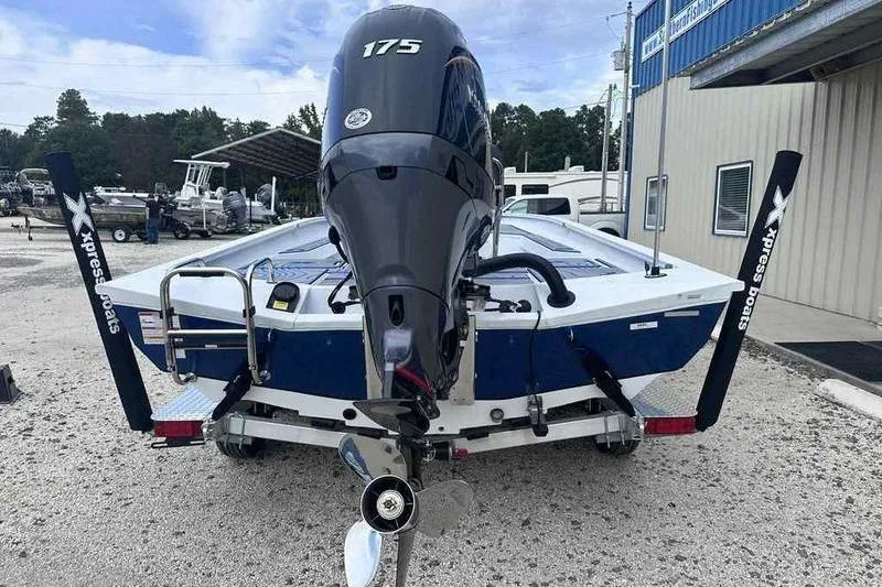 Slide: The Image of 2026 Xpress H22 boat with 175 horsepower engine, parked on gravel. - 2