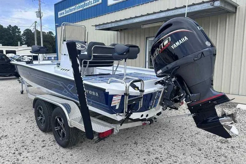 Slide: The Image of 2026 Xpress H22 boat with Yamaha outboard motor, parked on a trailer outside a building. - 9