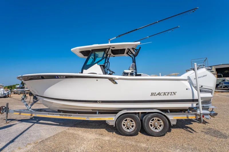 Slide: The Image of 2021 Blackfin 272 CC boat on trailer under clear blue sky. - 6