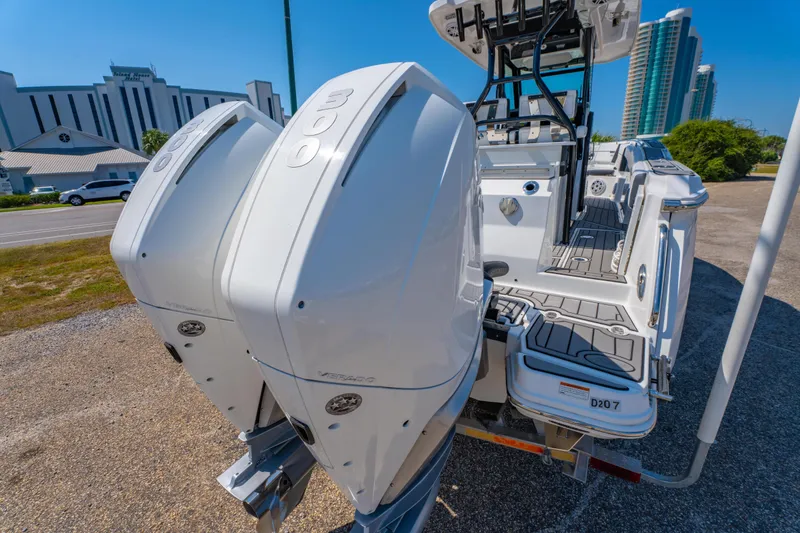 Slide: The Image of 2021 Blackfin 272 CC boat with dual outboard engines, parked near modern buildings. - 9